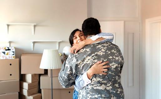 Wife and veteran husband hugging in new home